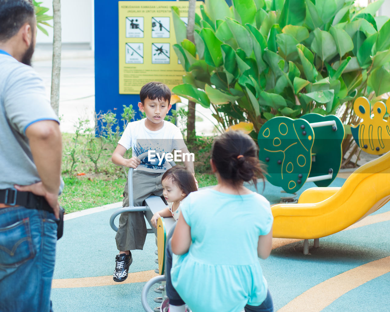 REAR VIEW OF PEOPLE WITH CHILDREN ON PLANT