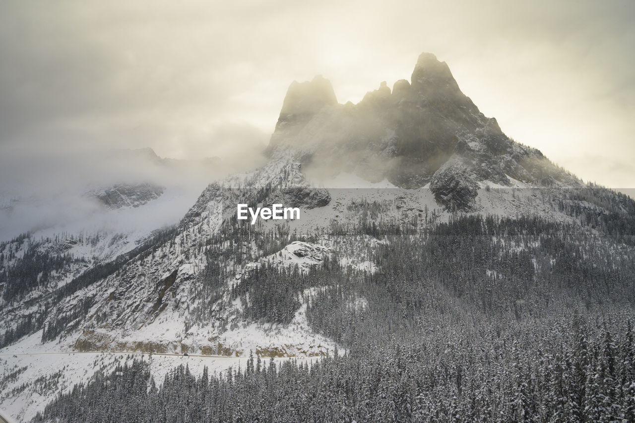 Moody backlit mountain peaks in the clouds