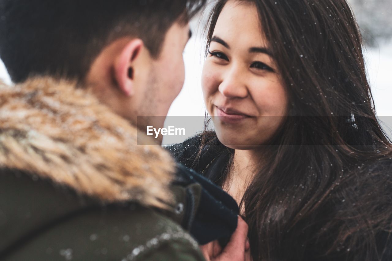 Close-up of young couple standing face to face during winter