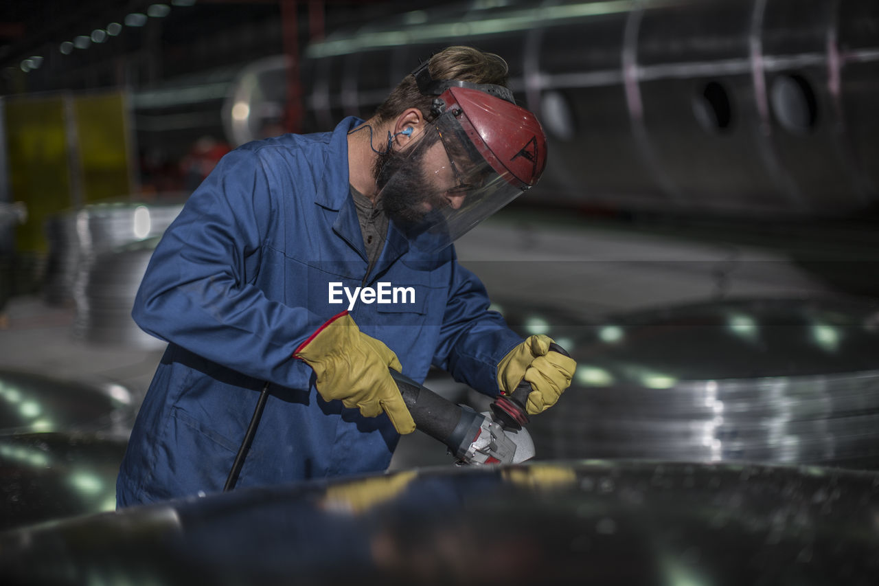 Factory worker operating steel cutter