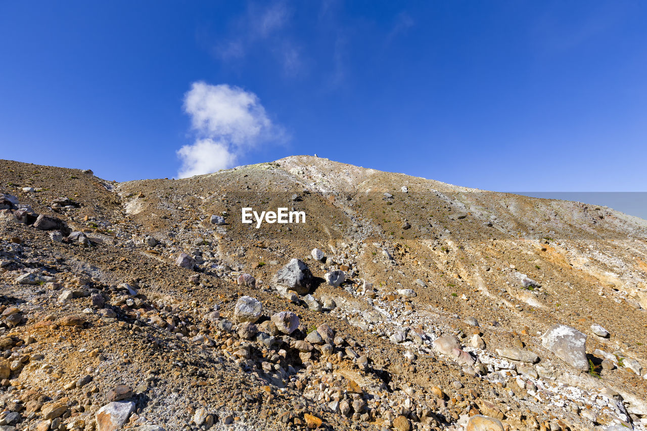 Low angle view of mountain against blue sky