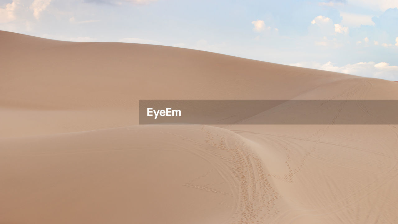 Sand dunes in desert against sky