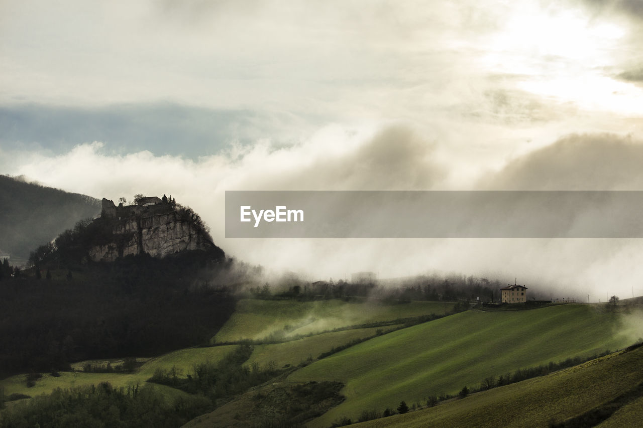 Scenic view of landscape against sky and fog, canossa