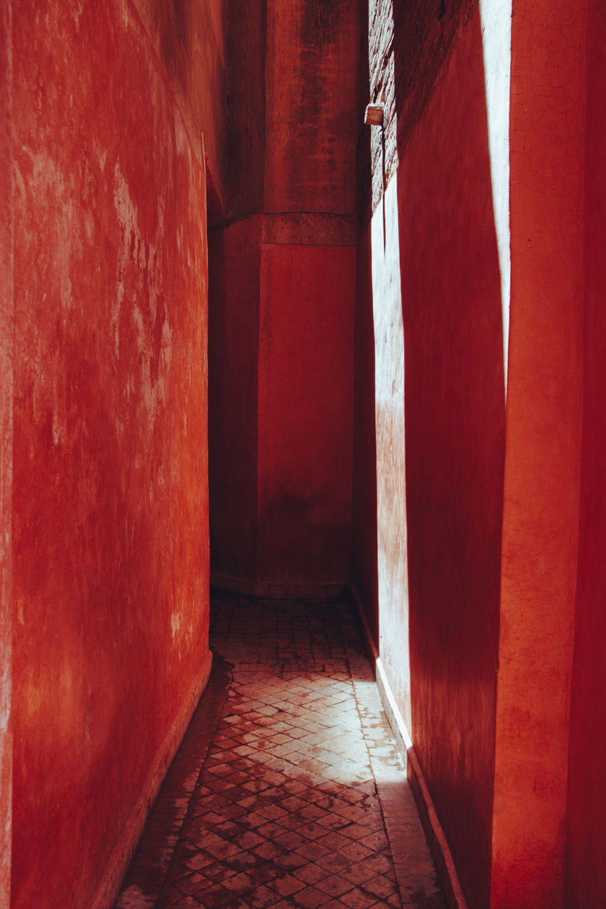 VIEW OF CORRIDOR OF BUILDING WITH RED CLOSED DOOR