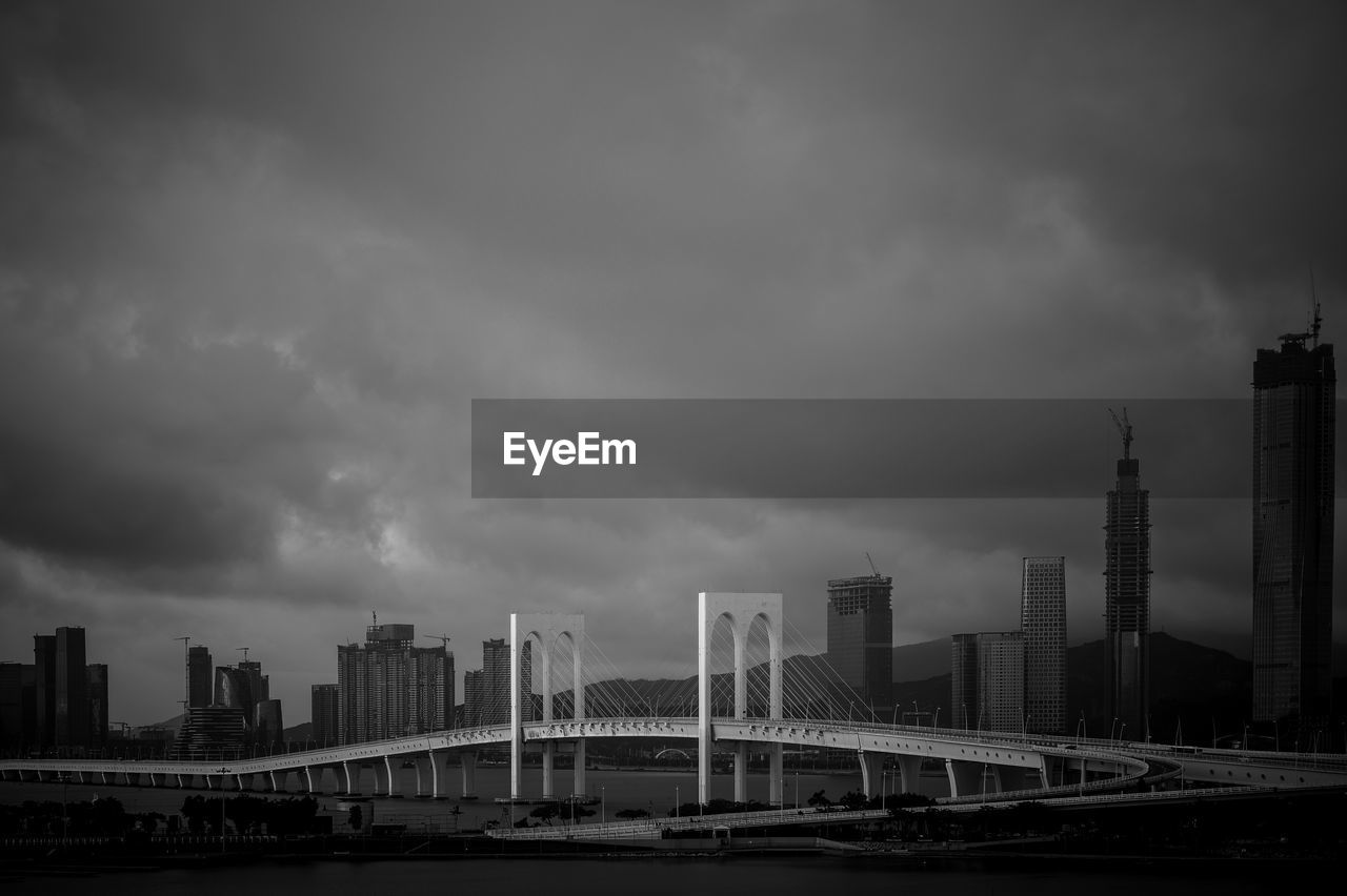 MODERN BUILDINGS BY BRIDGE AGAINST SKY IN CITY