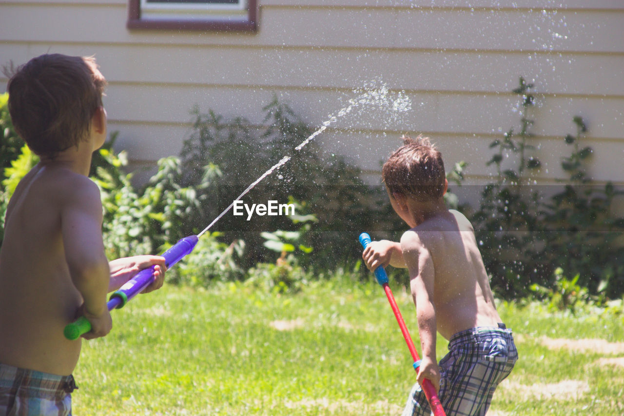 Children playing with water in yard