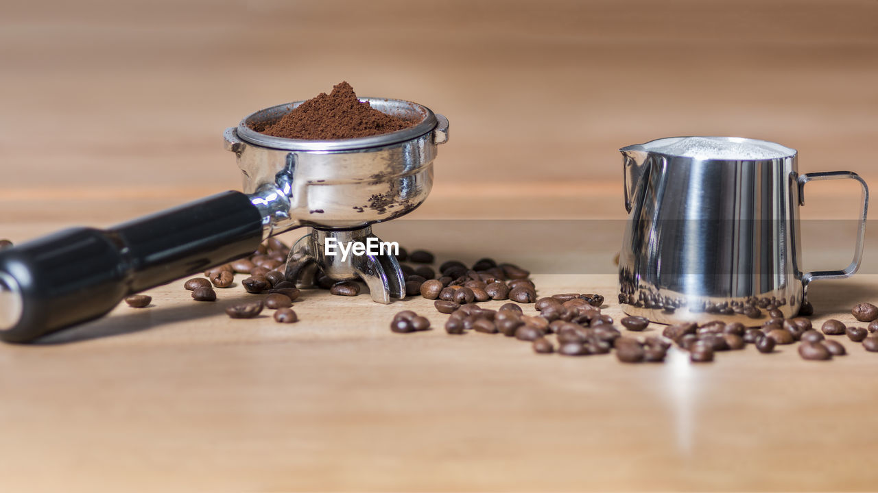 CLOSE-UP OF COFFEE BEANS ON TABLE AGAINST WALL