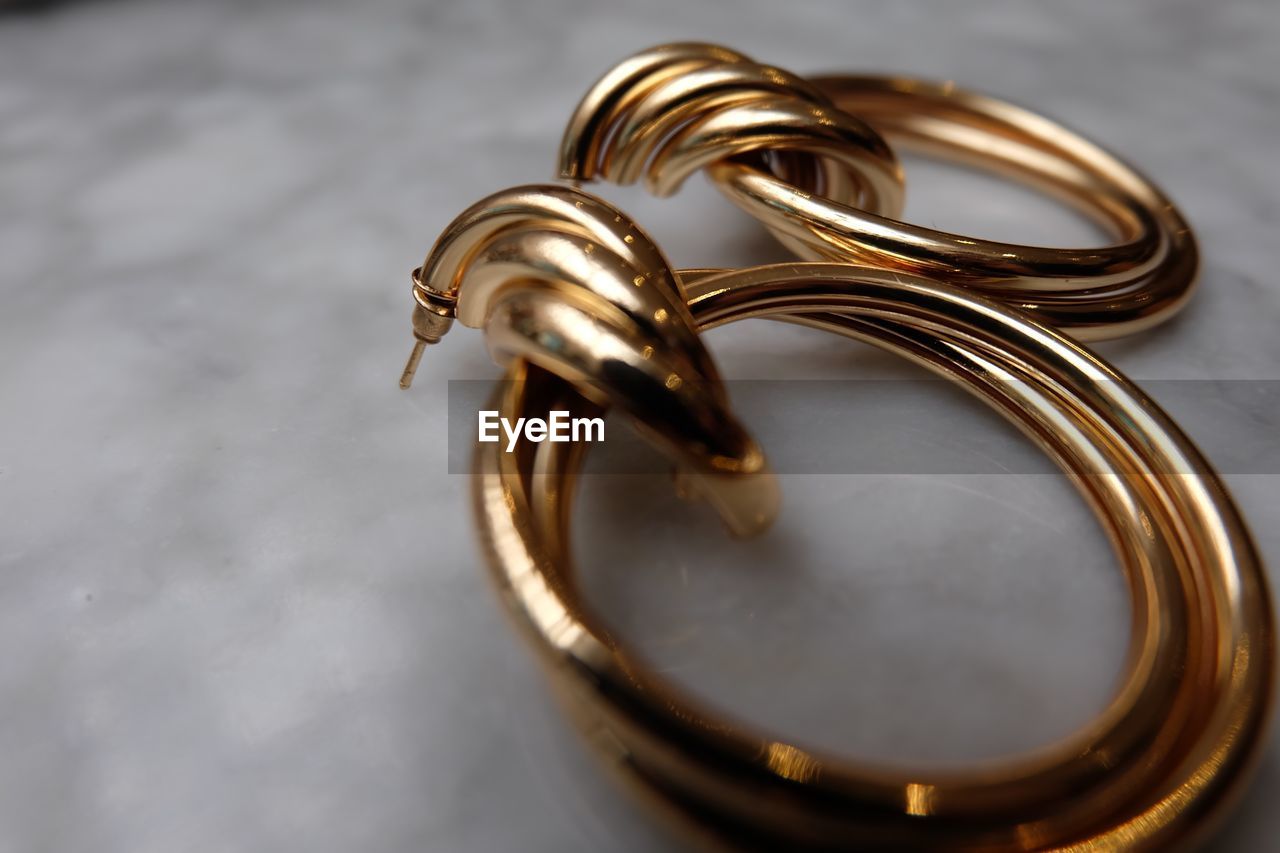 CLOSE-UP OF WEDDING RINGS ON METAL TABLE