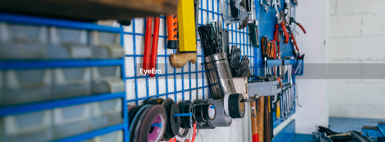 Close-up of various work tools hanging in workshop