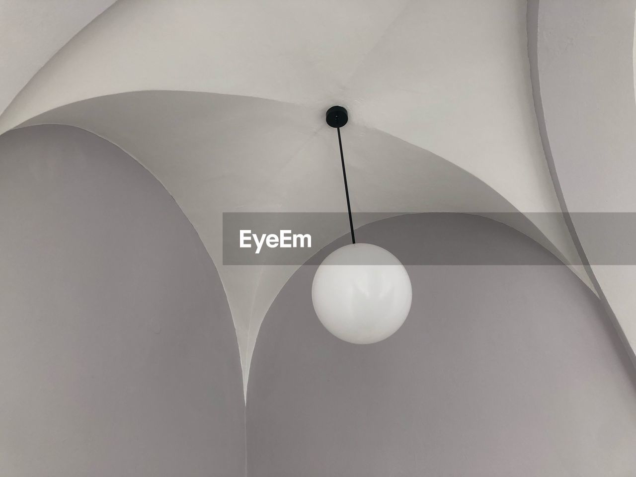 Low angle view of illuminated pendant light hanging from ceiling