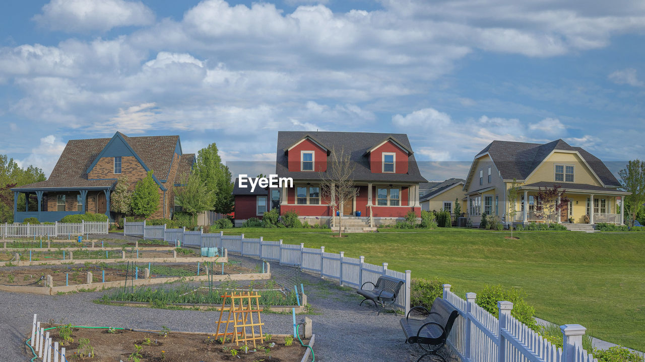 houses on field against cloudy sky