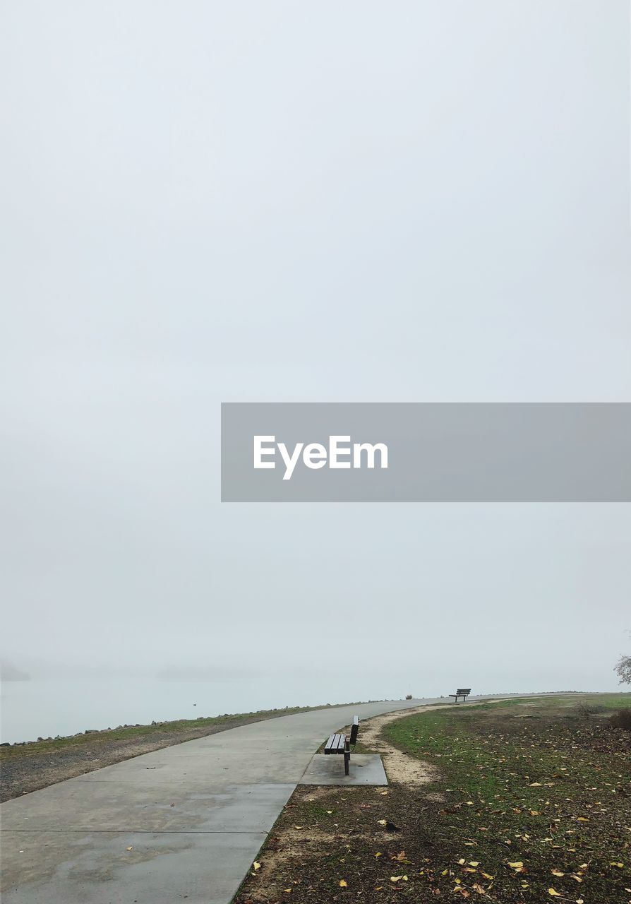 Road amidst field against sky