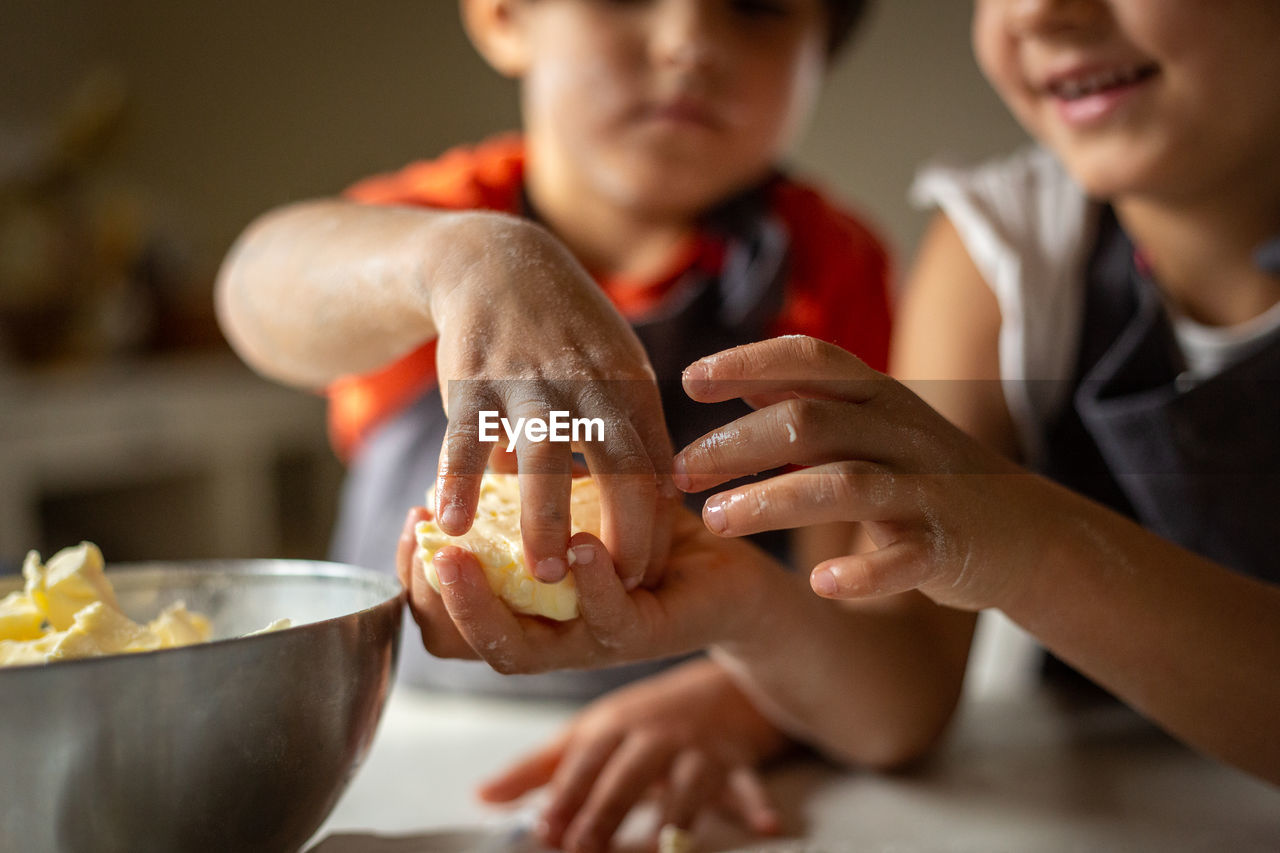 Close view of children's hands preparing food at home