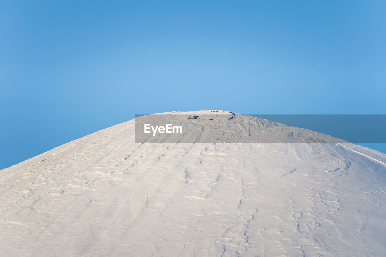 Scenic view of snowcapped mountain against clear blue sky