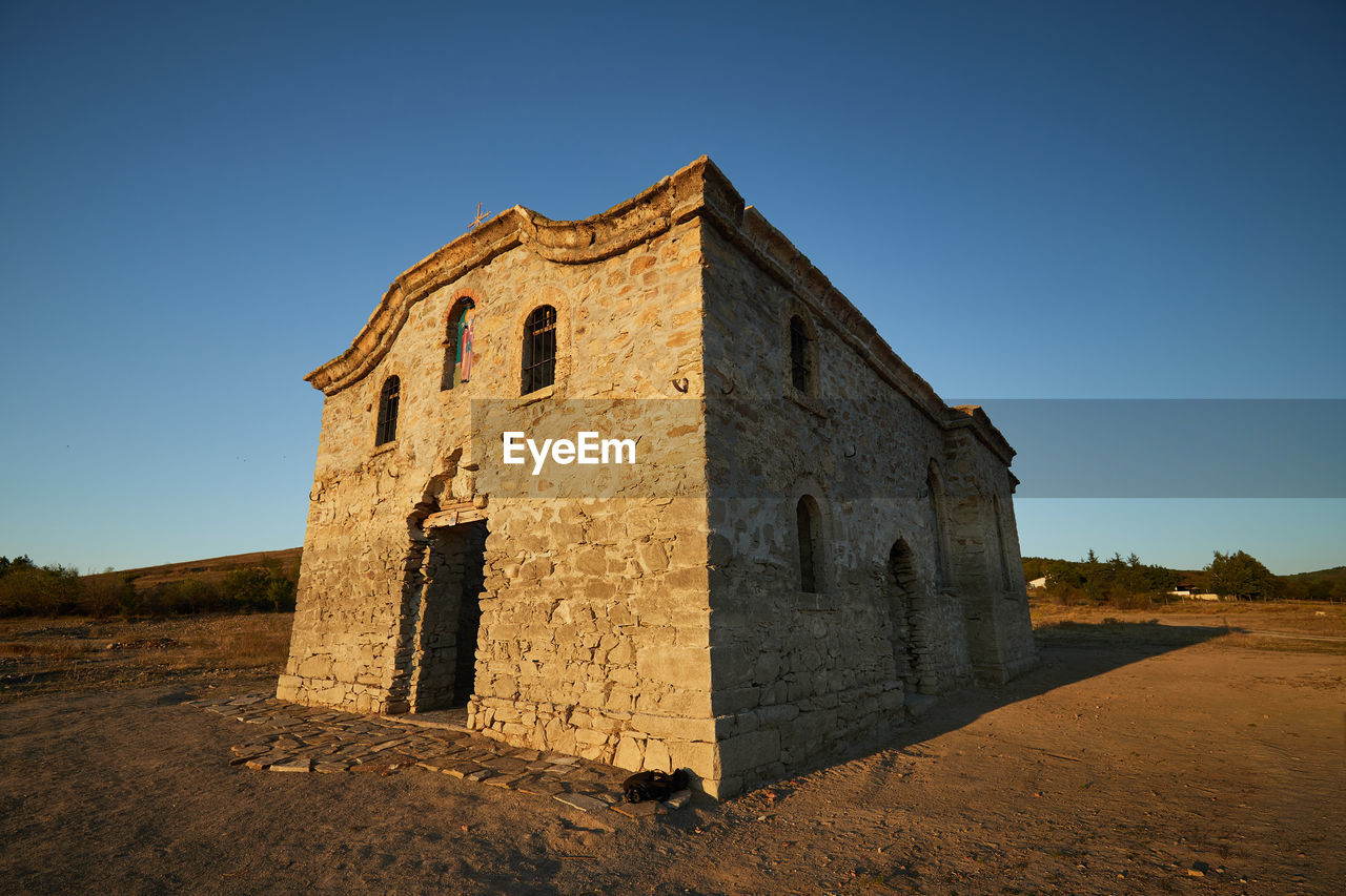 architecture, sky, built structure, history, the past, building exterior, clear sky, nature, building, blue, land, ancient history, landscape, travel destinations, travel, no people, religion, old, ancient, outdoors, abandoned, sunny, place of worship, ruins, tourism, sunlight, environment, belief, old ruin, rock