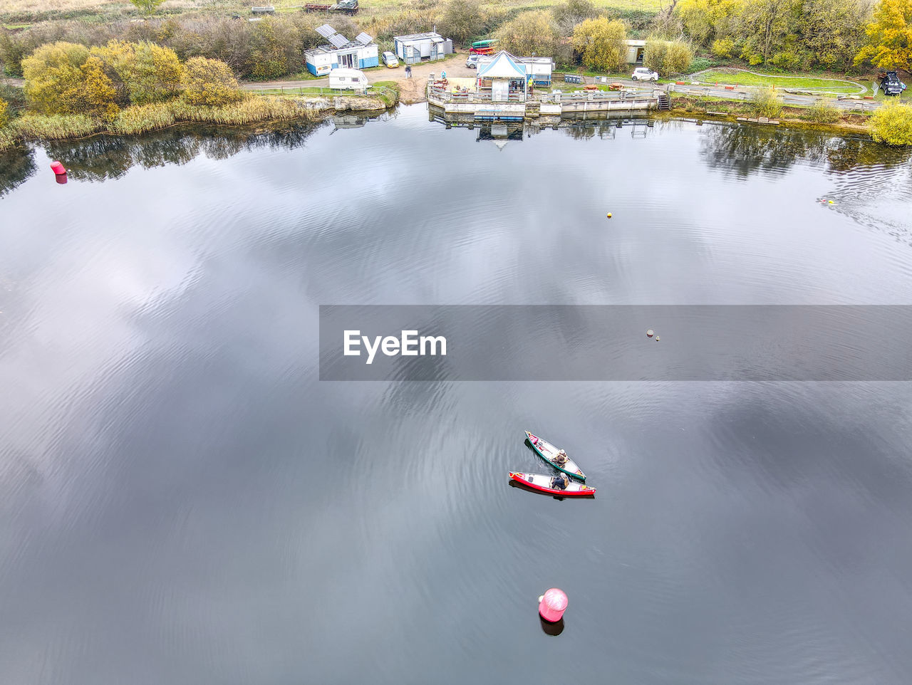 HIGH ANGLE VIEW OF BOATS IN LAKE AGAINST TREES