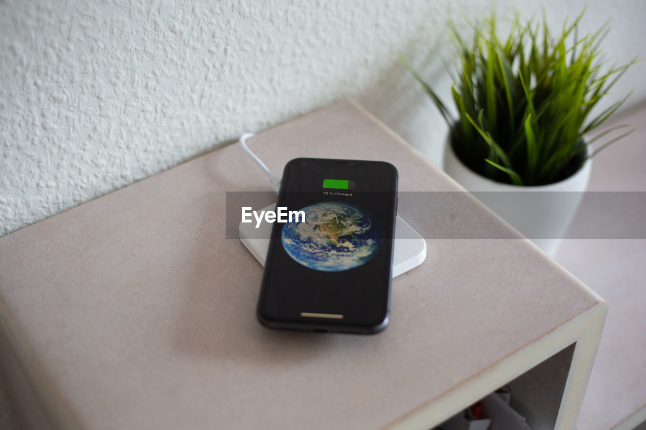 HIGH ANGLE VIEW OF SMART PHONE AND WOMAN ON TABLE