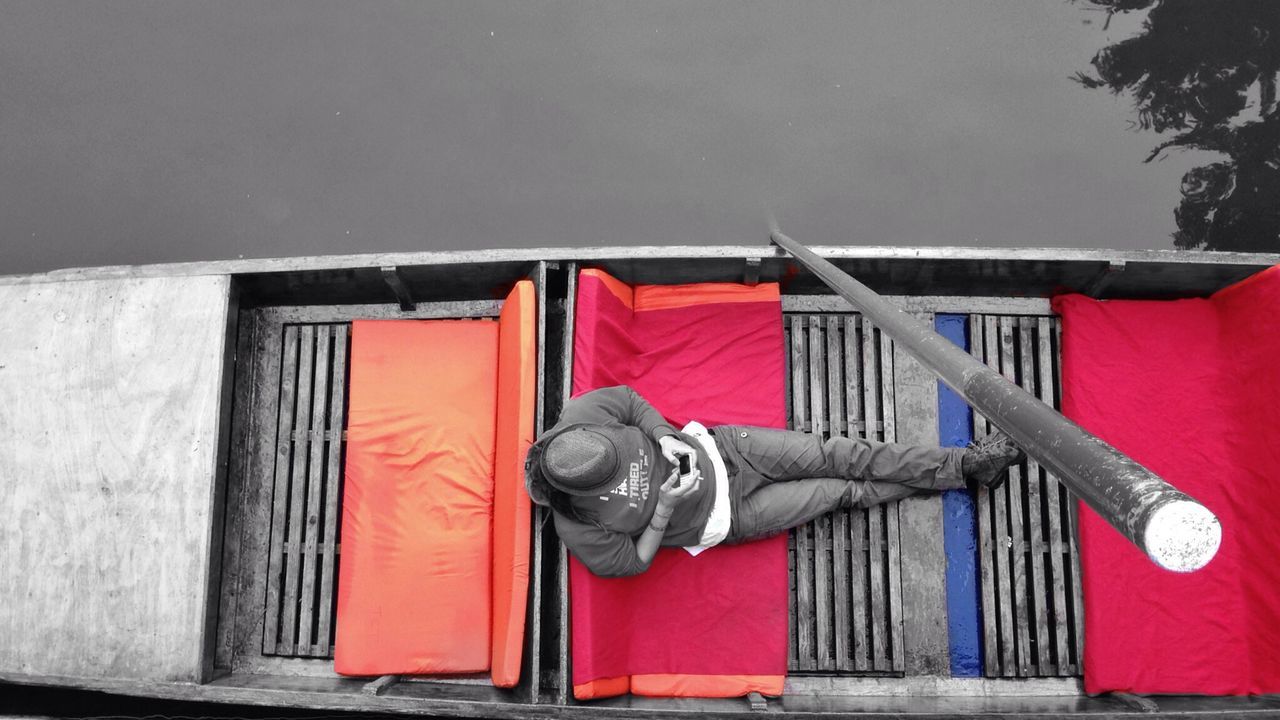 Directly above shot of man using mobile phone on boat