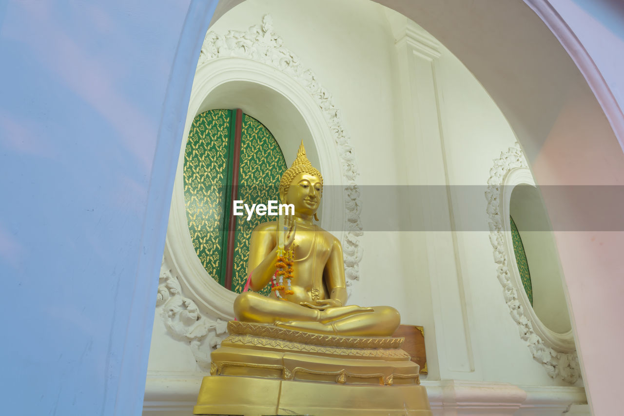 LOW ANGLE VIEW OF BUDDHA STATUE IN TEMPLE BUILDING