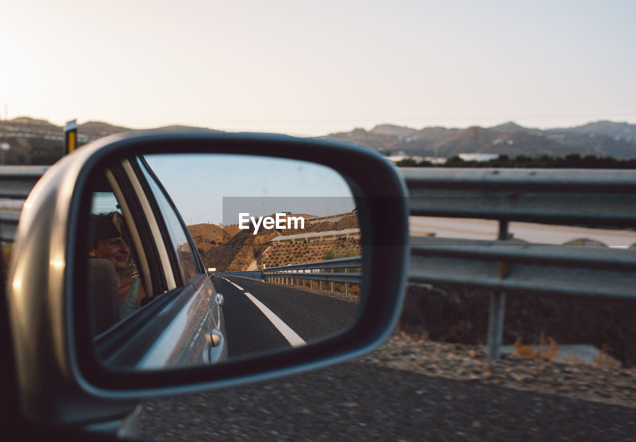 Close-up of side-view mirror against clear sky