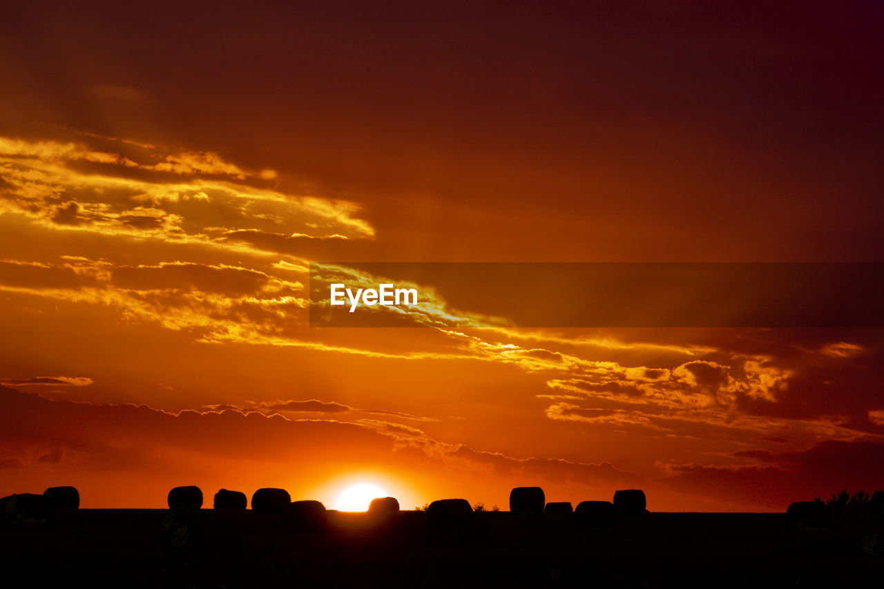 Scenic view of silhouette landscape against orange sky