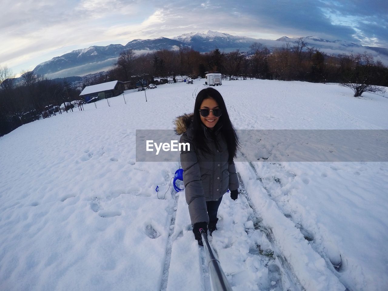 WOMAN STANDING ON SNOW COVERED ROAD