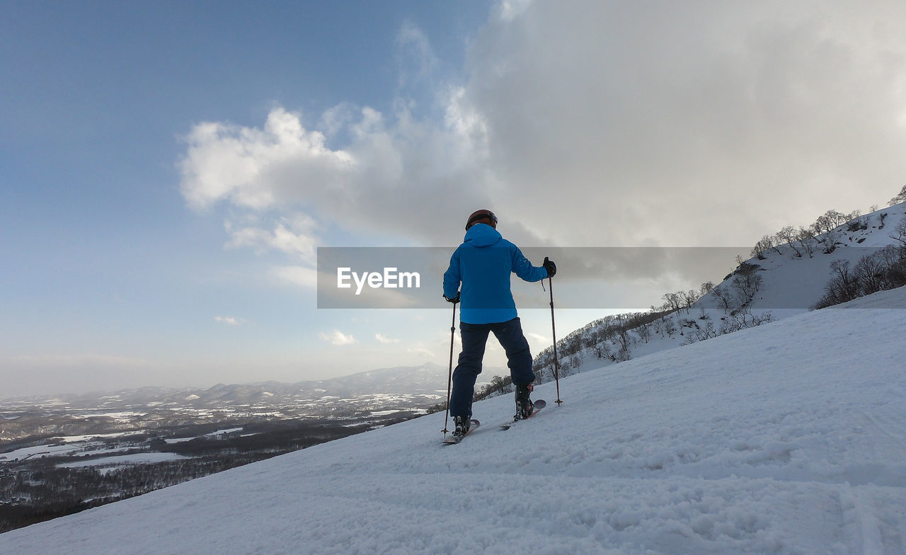 Low angle view of man skiing on snowcapped mountain against sky