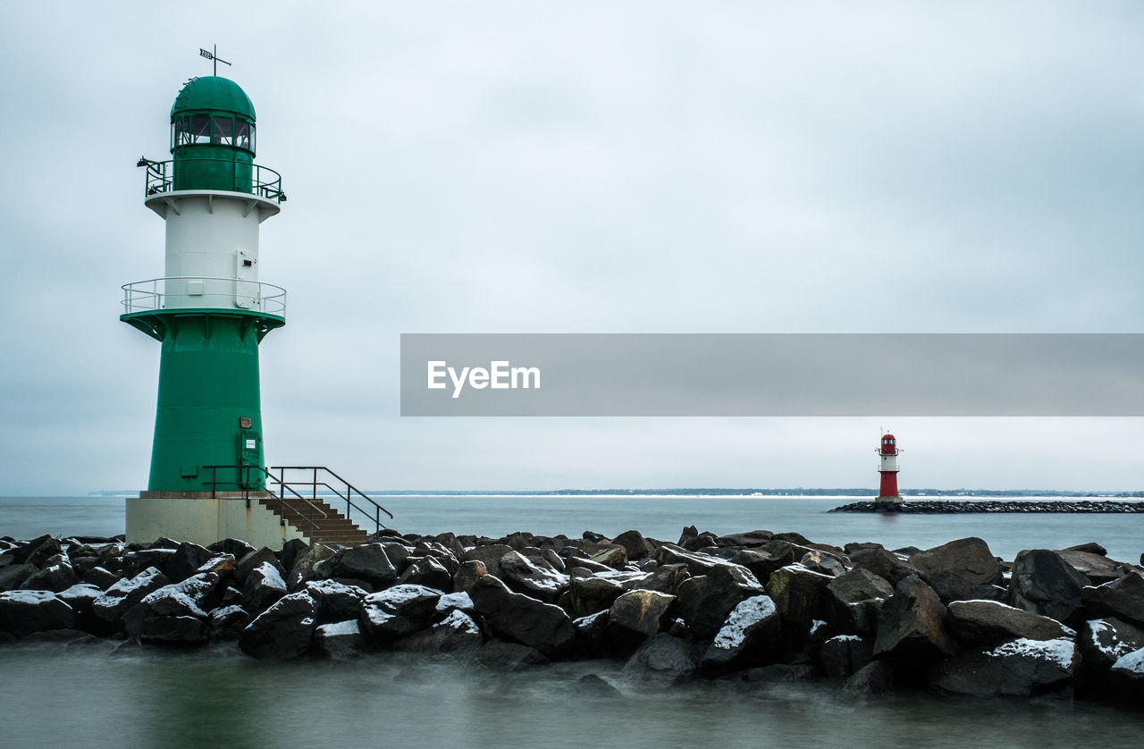 LIGHTHOUSE ON SHORE AGAINST SKY