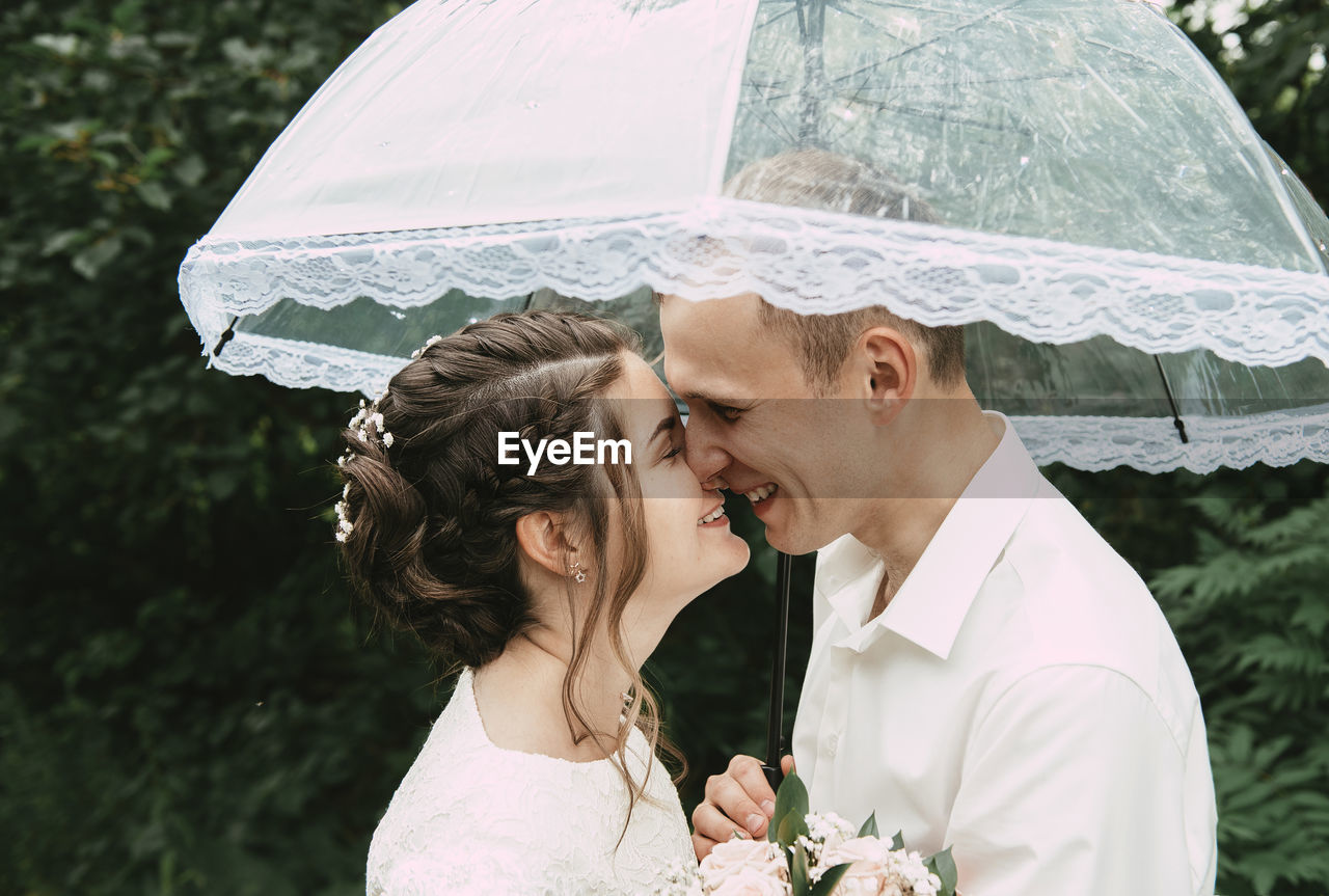 Close-up of couple with umbrella