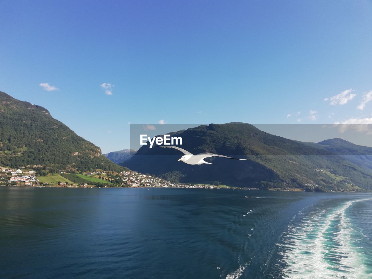 Scenic view of sea and mountains against blue sky