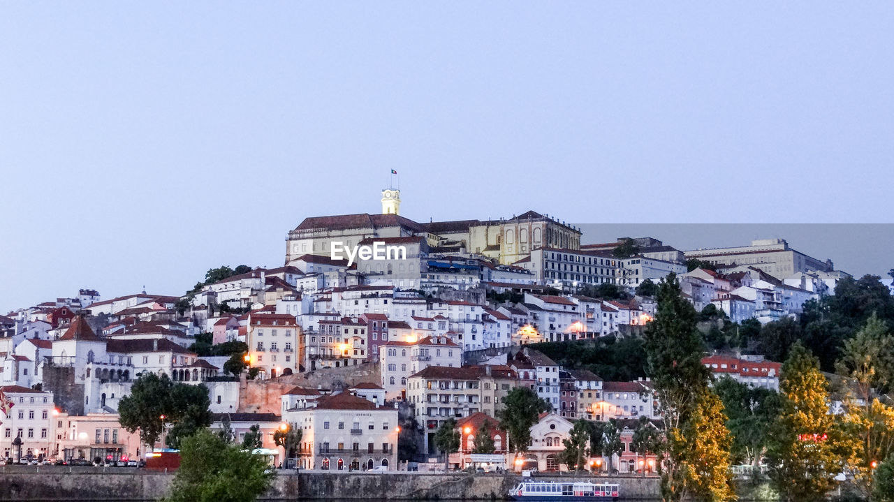 Buildings in city against clear sky