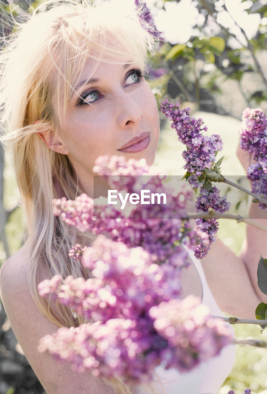 Close-up of woman by purple flowering plants