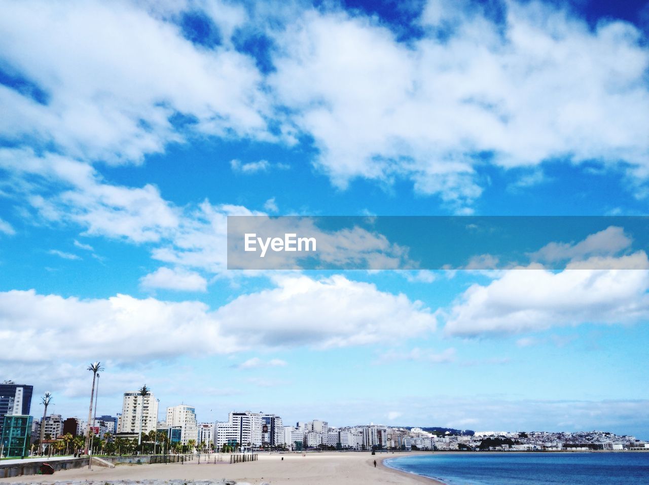 PANORAMIC SHOT OF BUILDINGS AND SEA AGAINST SKY