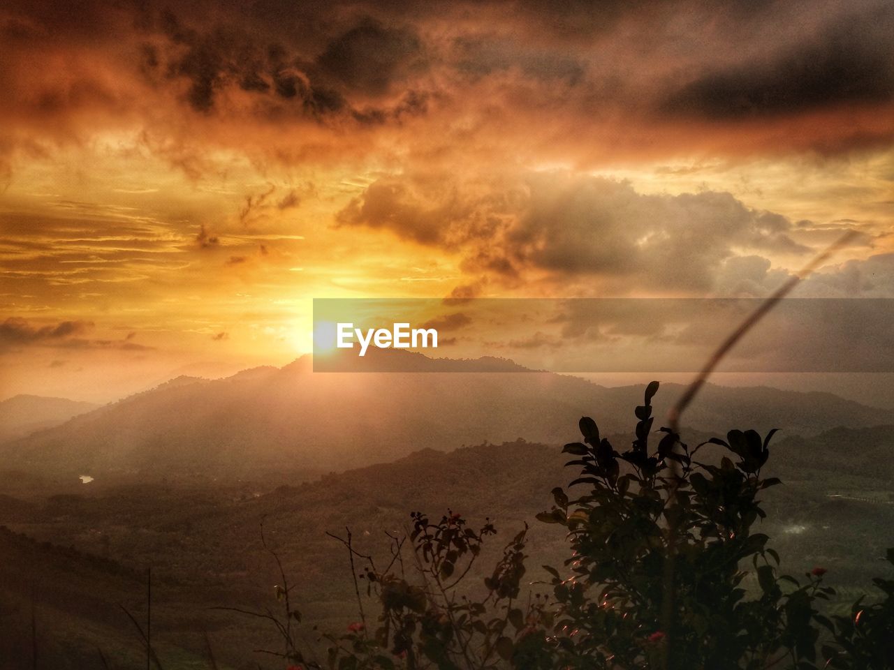 SCENIC VIEW OF SILHOUETTE MOUNTAINS AGAINST ORANGE SKY