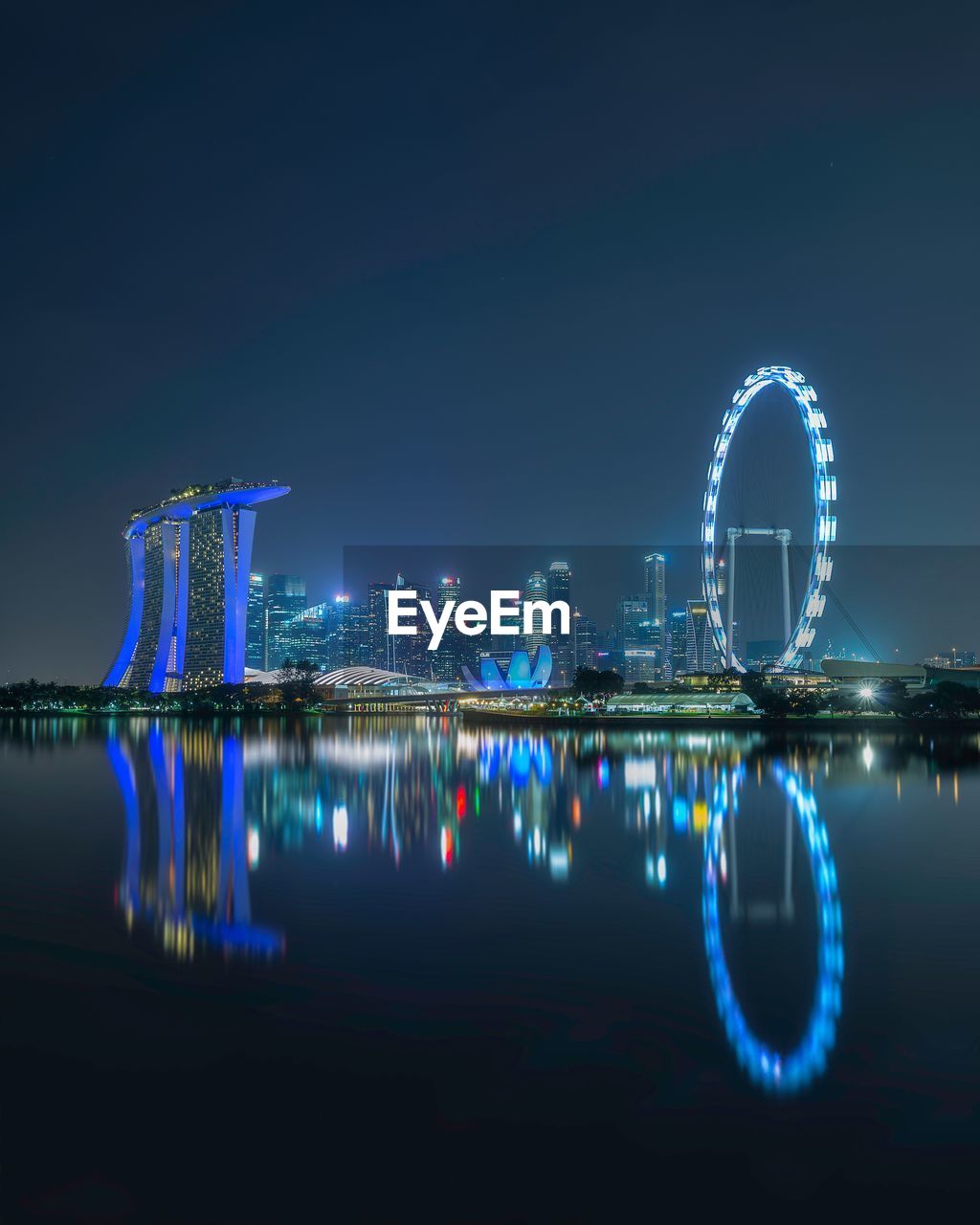 REFLECTION OF ILLUMINATED BUILDINGS IN CITY AT NIGHT