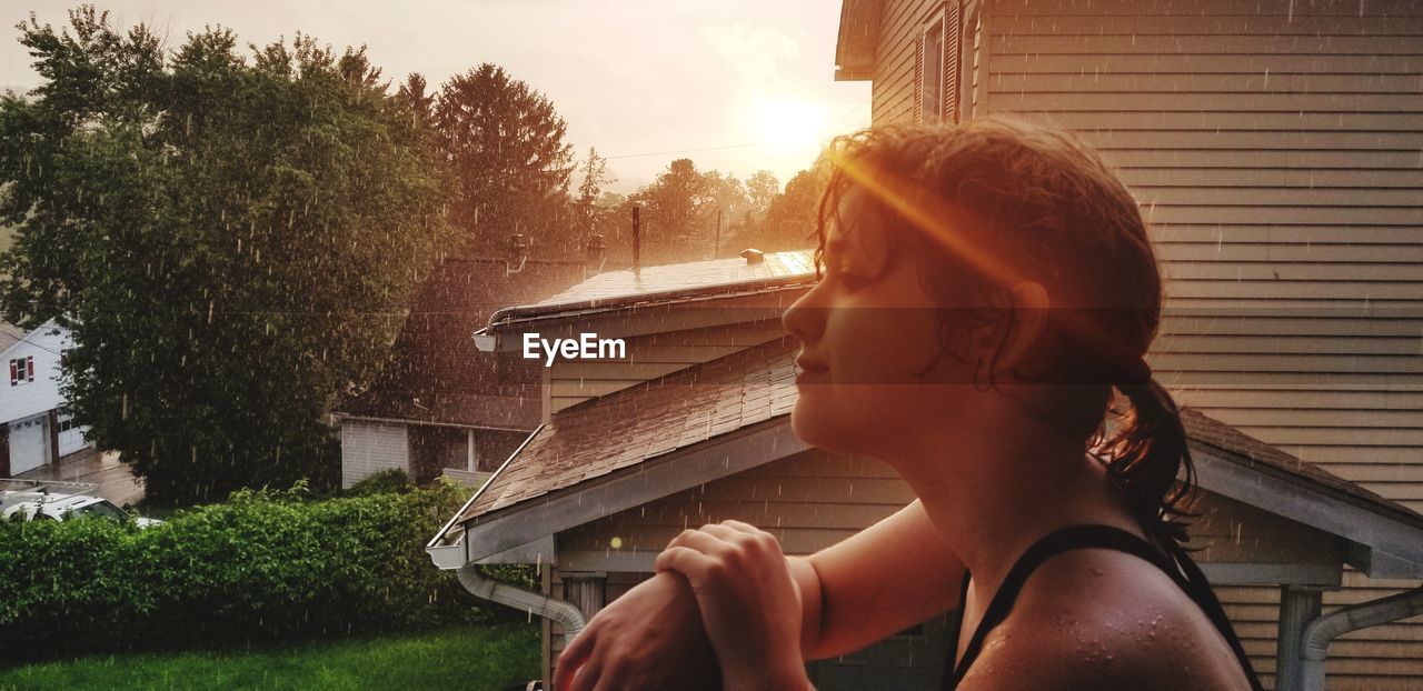 Side view of teenage girl looking away at backyard