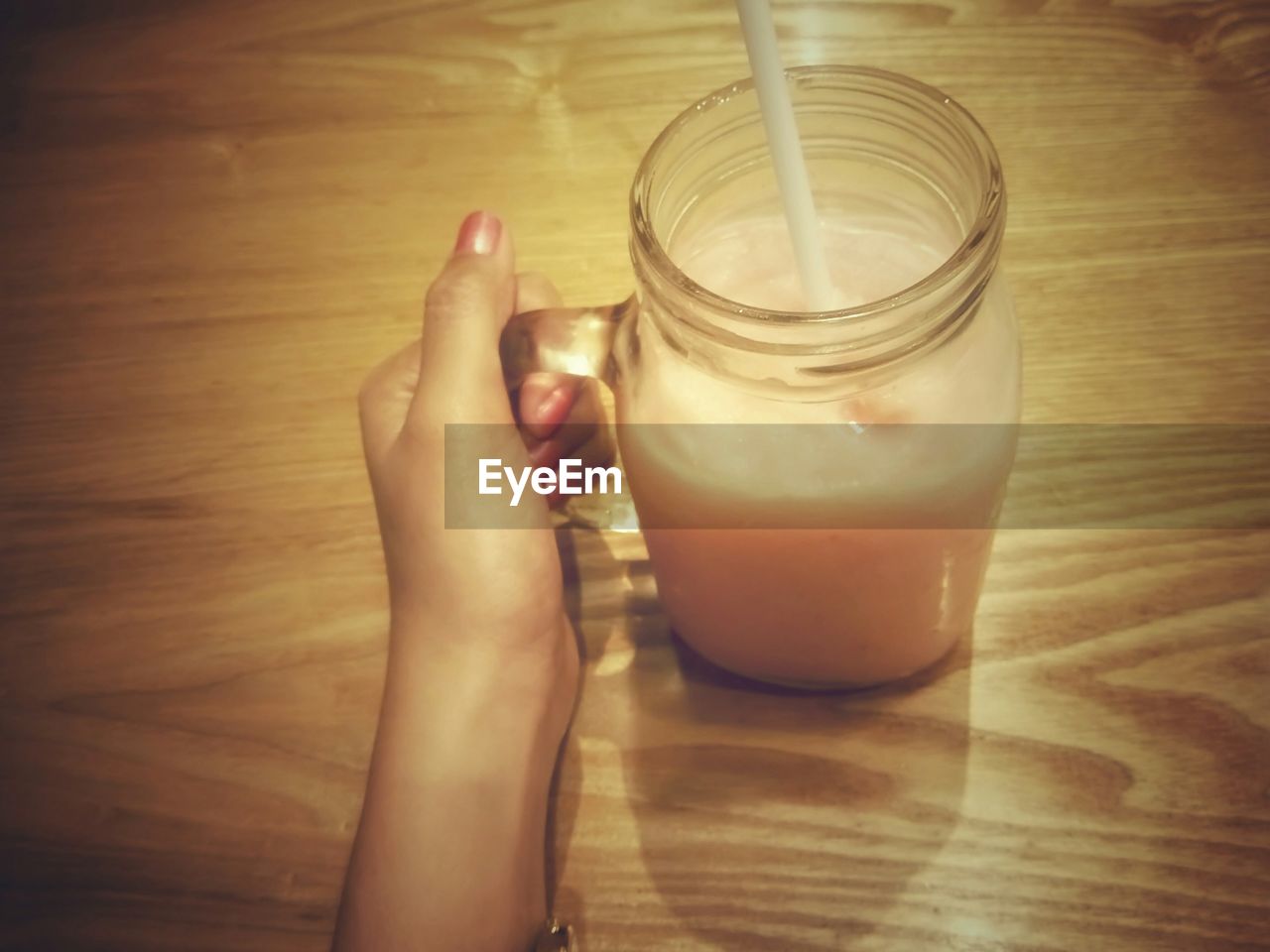 CROPPED IMAGE OF HAND HOLDING DRINK IN JAR