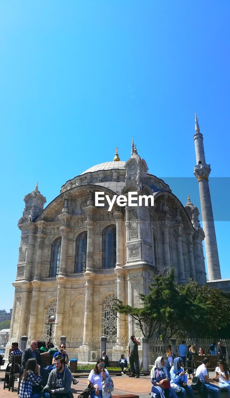 PEOPLE OUTSIDE TEMPLE AGAINST BLUE SKY