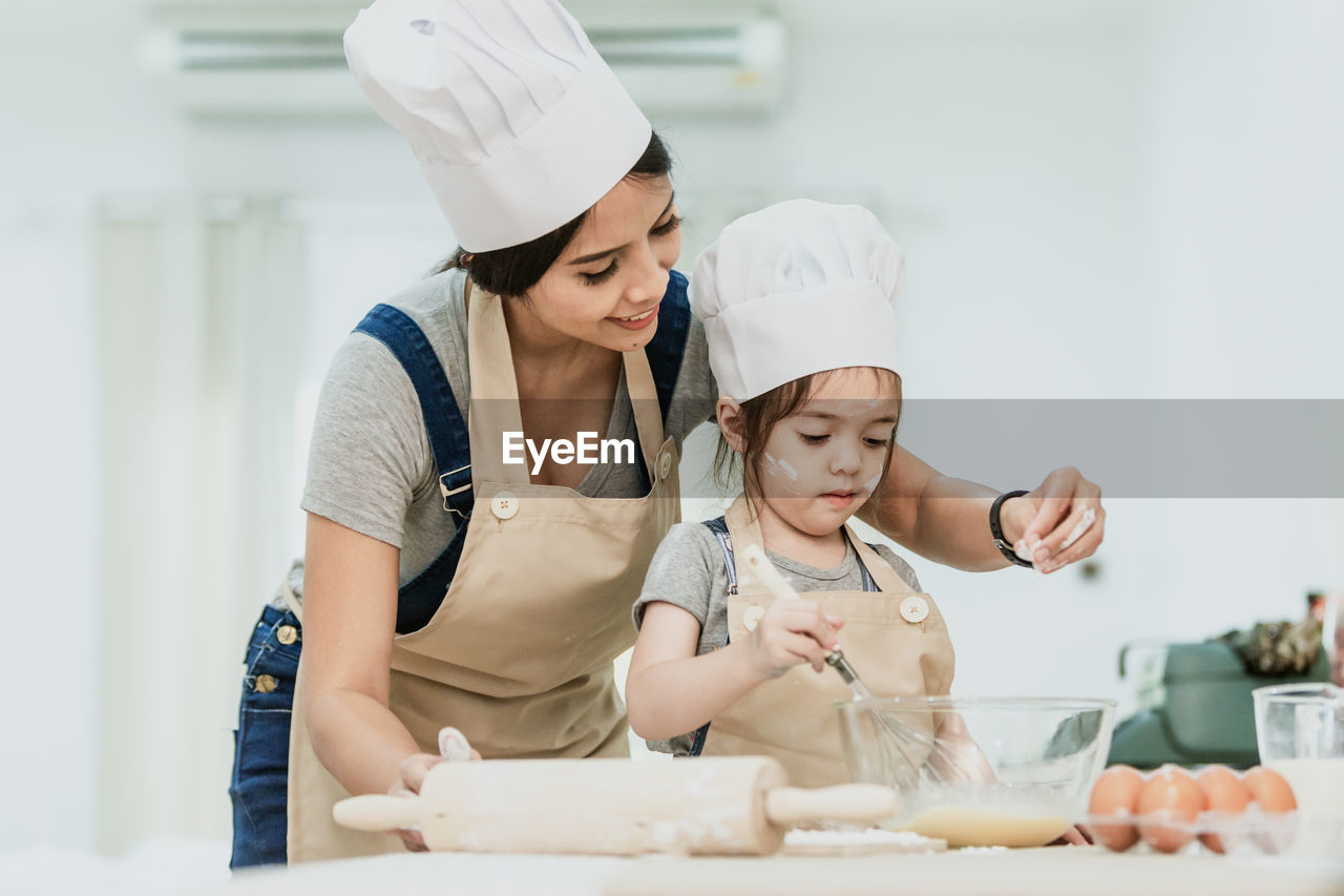 HAPPY FRIENDS STANDING IN KITCHEN