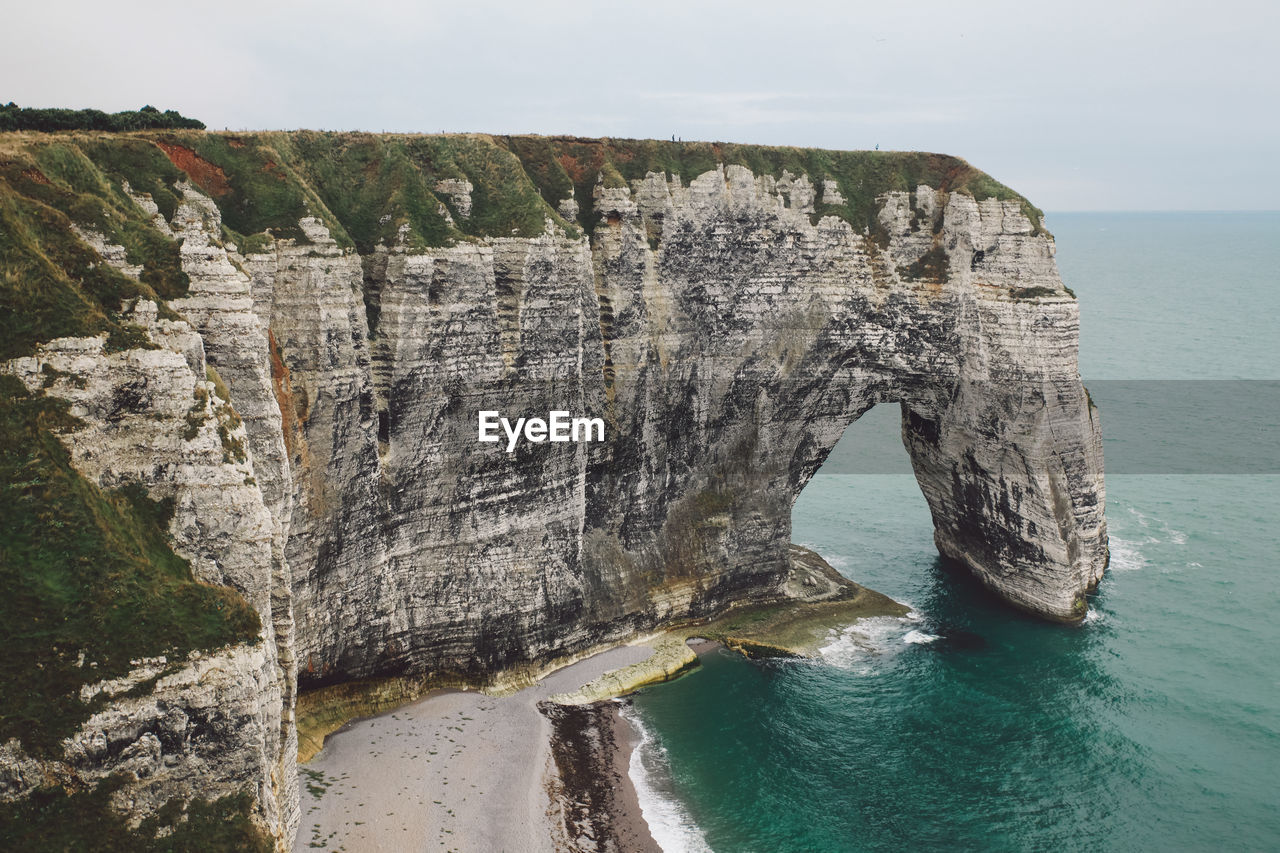 Rock formations by sea against sky