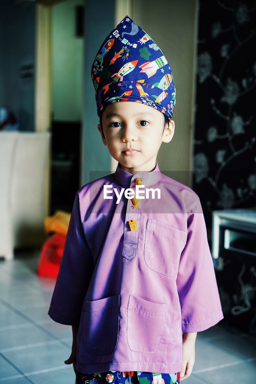 Portrait of cute boy standing at home
