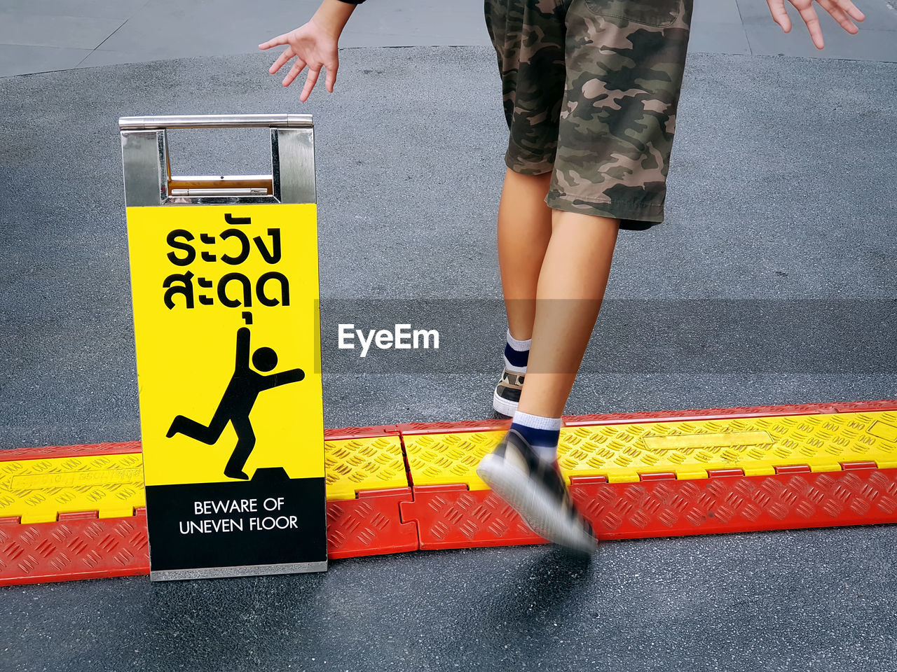 Low section of man walking on road in city