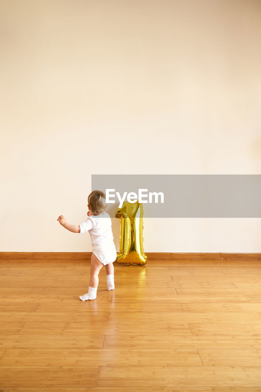 Full length of woman standing on wooden floor at home