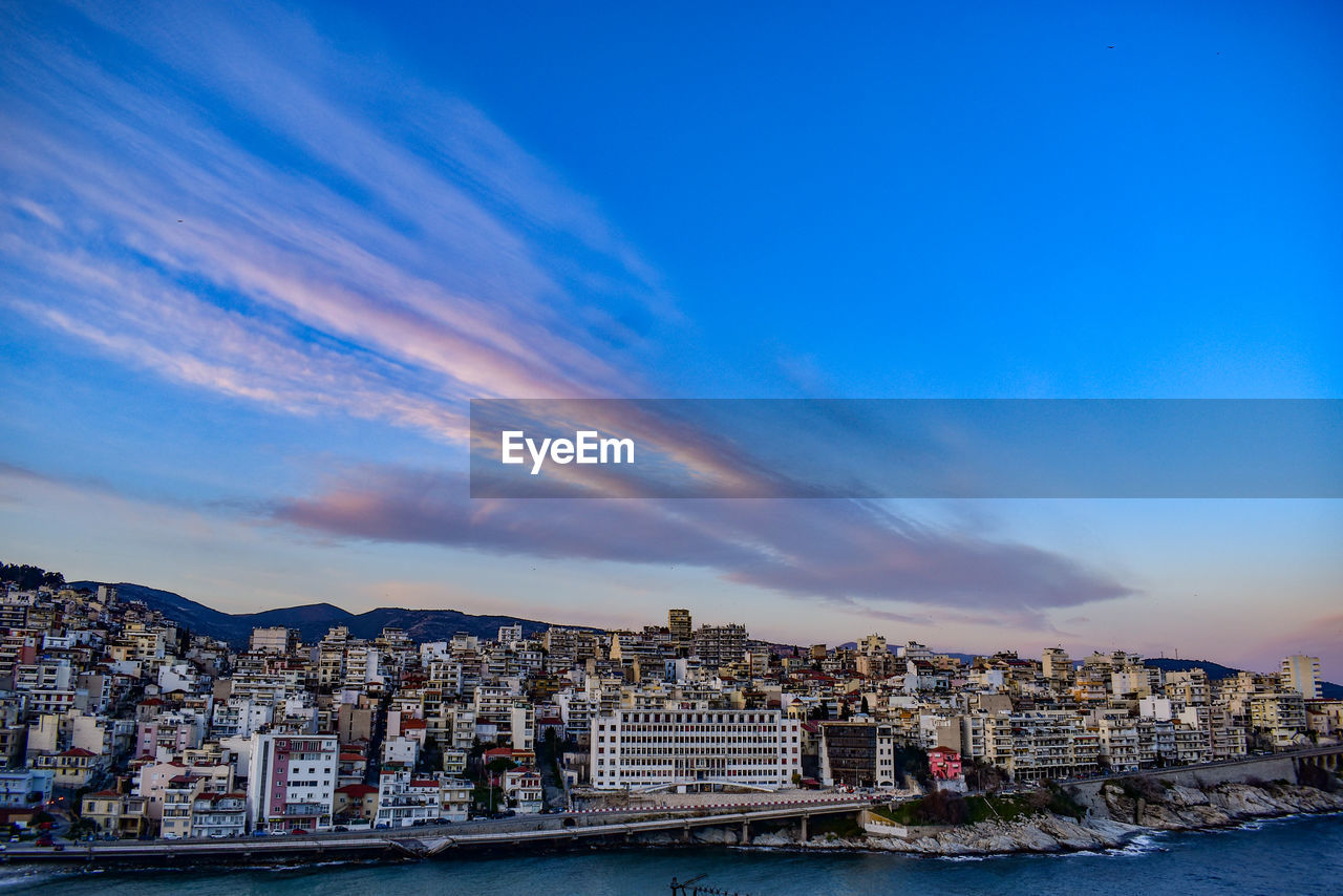 Buildings in city against cloudy sky