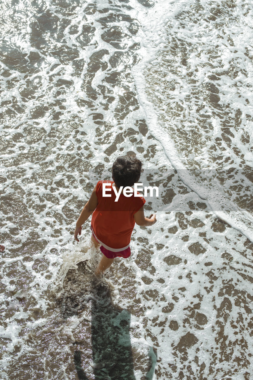 Rear view of boy at beach