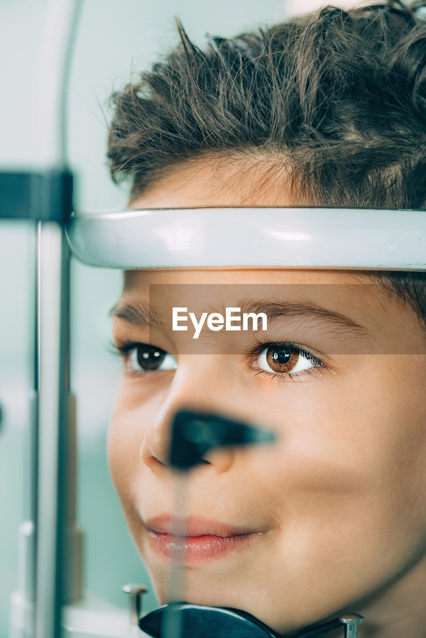 Close-up of boy with eye test equipment