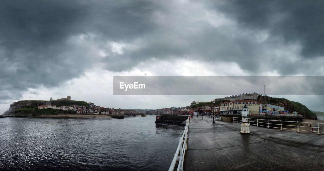 Bridge over lake against cloudy sky