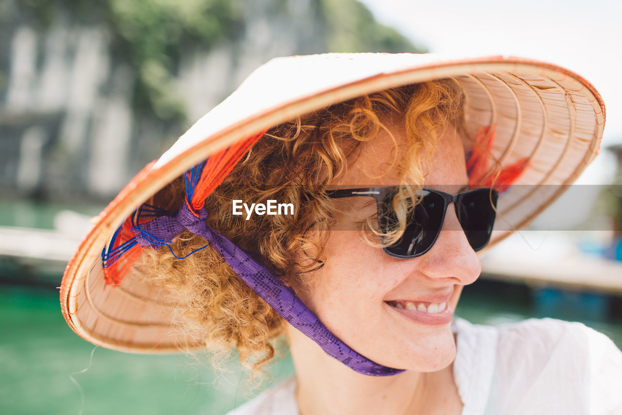 Close-up of smiling woman wearing sunglasses and hat