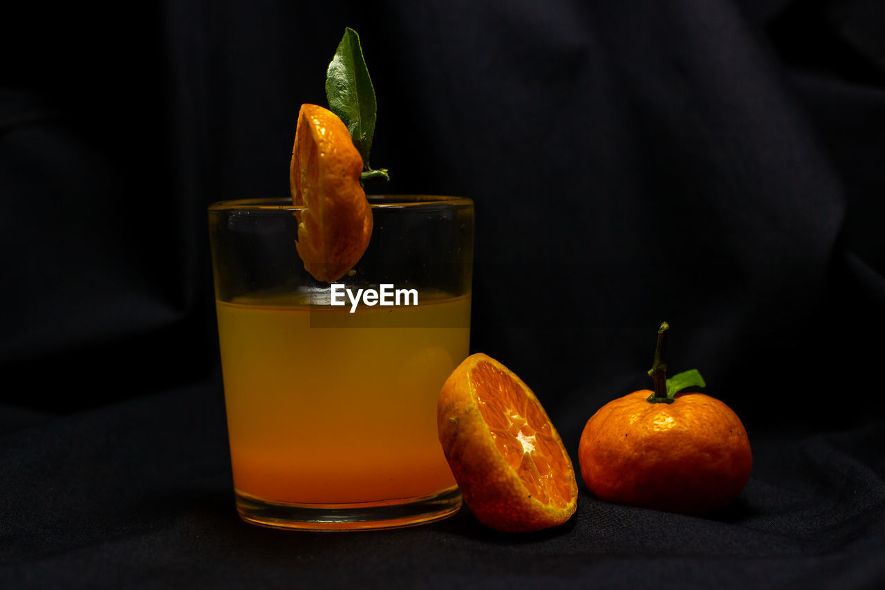 CLOSE-UP OF ORANGE AND JUICE ON TABLE