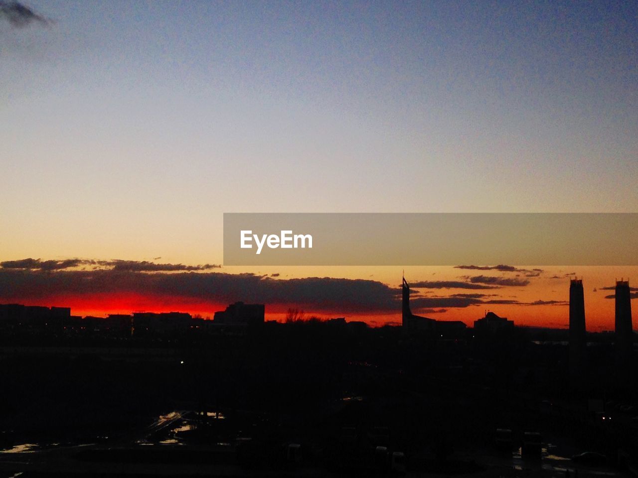 Silhouette buildings against sky at sunset